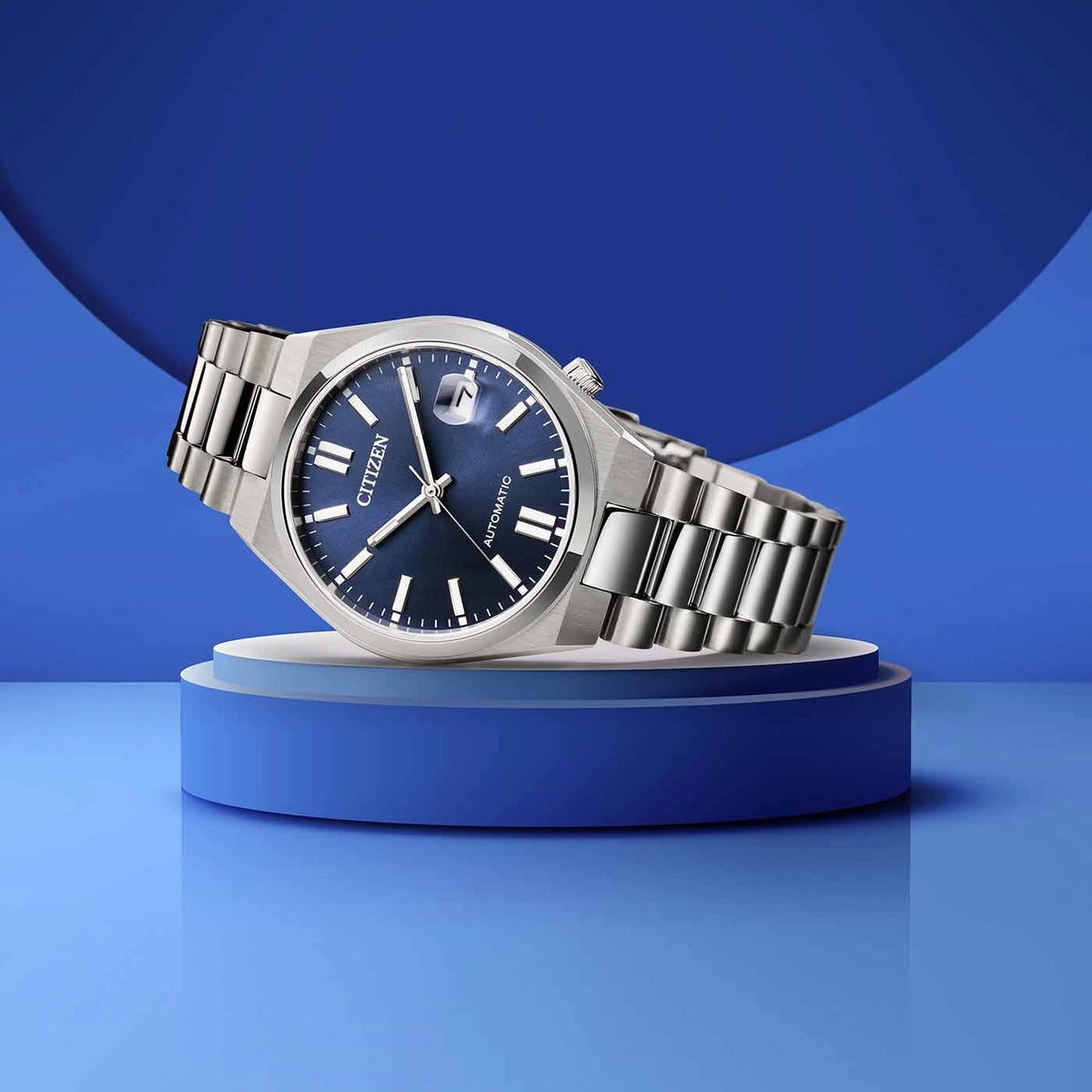 Une montre argentée de marque Citizen avec un cadran bleu sur un présentoir bleu.